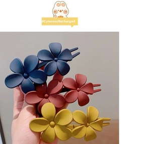Détail de trois pinces à cheveux fleurs mates en bleu marine, bordeaux et jaune moutarde