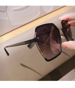 Close-up of semi-rimless sunglasses with gold metal trim and dark gradient lenses