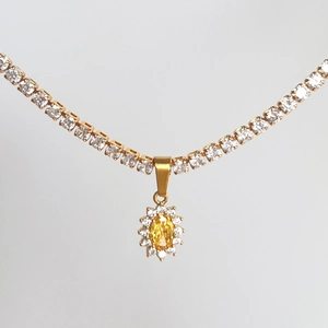Macro shot of 18k gold plated necklace with oval yellow zircon and white diamond halo