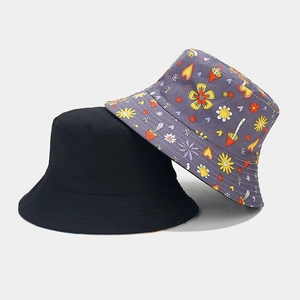 Détail d'un motif de fleurs et champignons et d'un bob réversible noir uni en coton