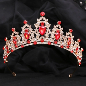 Detailed macro view of golden crown with red teardrop crystals and clear rhinestones