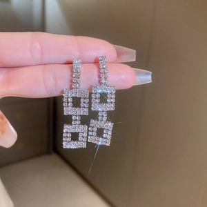 Detail of silver geometric square drop earrings with sparkling rhinestone crystals