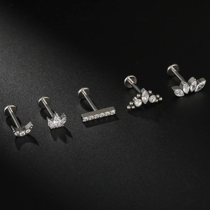 Macro detail of G23 titanium labret studs with crescent moon and crown zircon settings