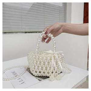 Détail d'un sac panier en perles blanches avec doublure en satin et nœud décoratif