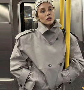 Detail view of double-breasted trench coat with lapels and shoulder straps in urban setting