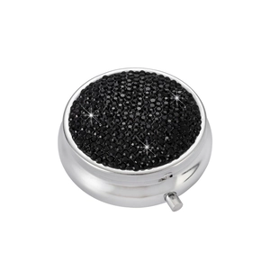 Detail view of the silver metal pill box with sparkling black rhinestones on the lid