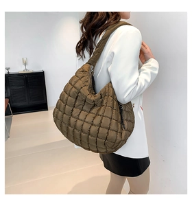 Side view of a large khaki quilted shoulder bag worn by a model for daily style