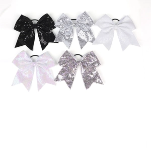 Détail de cinq élastiques à nœuds pailletés en noir, argent, blanc et tons violets