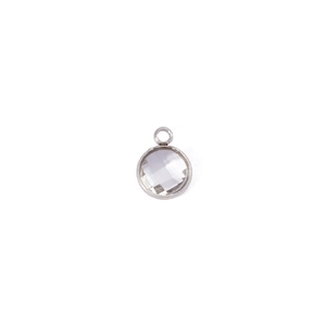 Macro shot of 7mm round clear birthstone pendant with silver metal bezel and bail
