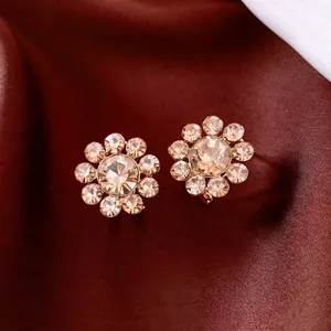 Elegant 14K gold plated sunflower earrings with champagne crystals on red silk background