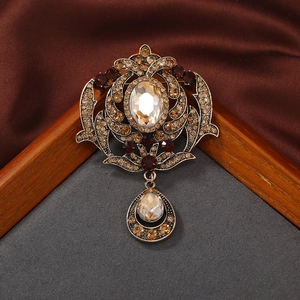 Vintage palace style bronze brooch with champagne rhinestones on brown silk background