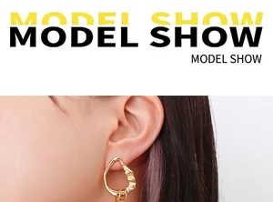 Detail shot of French style irregular faux pearl earrings with 18k gold plating on model