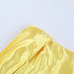 Detailed macro view of yellow satin fabric with high-gloss texture and fine woven grain