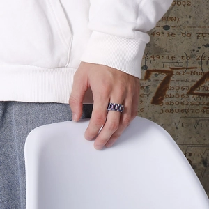 Street style chain ring with a watchband texture shown on model in industrial setting