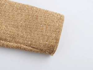 Macro shot of tweed fabric texture with gold metallic threads and shimmering sequins