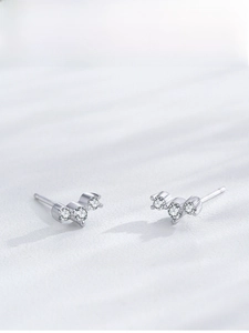 Detailed macro view of S925 sterling silver earrings with three zircon stones in curved design