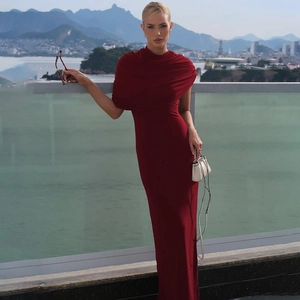 Détail d'une robe rouge foncé à épaule dénudée avec drapé froncé et texture soyeuse