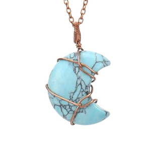 Detailed close-up of wire-wrapped crescent moon necklace with natural turquoise stone