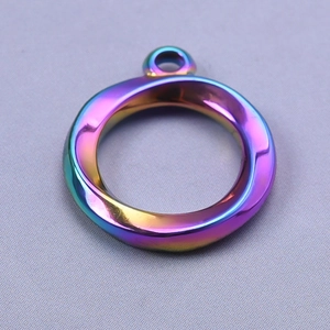 Macro shot of circular rainbow stainless steel pendant with twisted hollow design