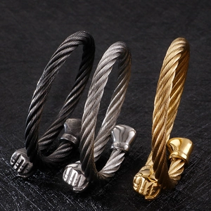 Detailed view of cable texture cuff bracelets with fist-shaped ends in three metallic colors