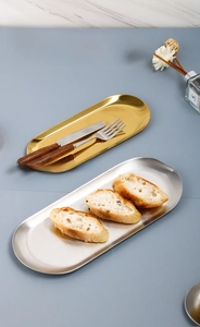 Close-up of gold and silver oval stainless steel trays for jewelry and cutlery storage