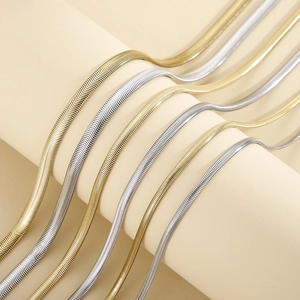 Colliers élégants en maille serpent dorée et argentée sur des supports minimalistes