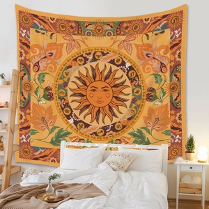 Detail of bohemian tapestry featuring sun face and zodiac symbols on bedroom wall