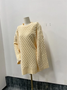 Détail de la maille torsadée et du col rond sur ce pull à manches longues jaune pâle en tricot