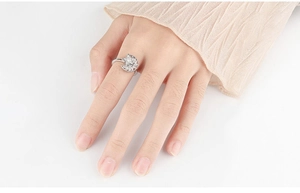 Detailed view of silver rotating spinner ring with zircon flower on female hand