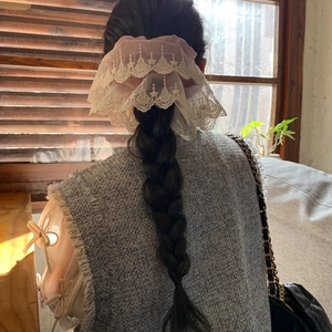 Elegant pink fabric scrunchie with cream lace edges shown on a braided hairstyle