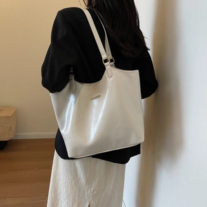 Minimalist creamy white leather tote bag shown on model in stylish office outfit