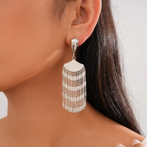 Side view of model wearing silver fan-shaped fringe earrings with metallic finish