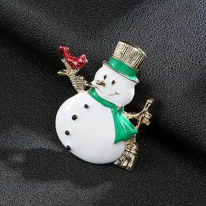 Weihnachts-Schneemann-Brosche mit grünem Hut und rotem Vogel auf schwarzem Leder