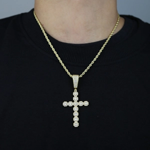 Close-up of golden hip hop cross pendant with shimmering cubic zirconia on rope chain