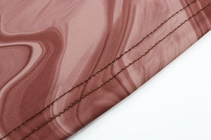 Détail de la couture à double aiguille et de l'imprimé marbré sur tissu en maille