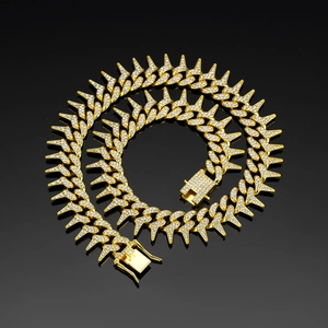 Macro view of iced out gold Cuban link necklace with sharp spikes and pave zircons