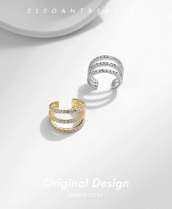 Close-up of gold and silver triple-layered ear cuffs with sparkling crystal inlay
