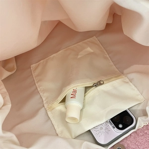 Detail view of the plush shoulder bag interior featuring a secure zipper pocket and lining