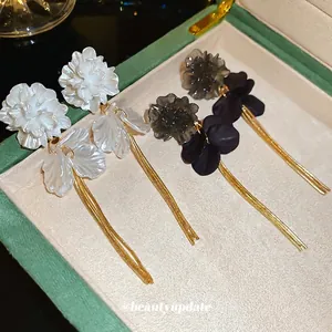 Elegant acrylic flower tassel earrings with pearl white and smoke grey petals in a jewelry box