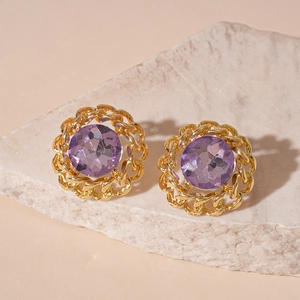 Detailed macro shot of vintage gold chain-link stud earrings with purple crystal stones