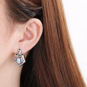 Close-up of minimalist square stainless steel stud earring with mother of pearl inlay on model