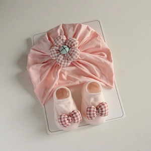 Detailed view of pink infant turban and socks set with checkered flower decorations