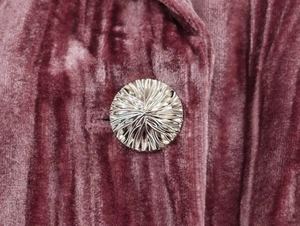 Macro detail of high-quality velvet fabric and silver embossed metal button for suits