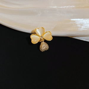 Detailed close-up of a gold-plated clover brooch with opal petals and a zircon heart pendant