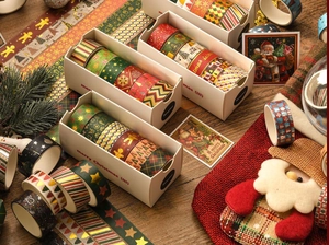 Close-up of Christmas washi tape set with gold foil patterns on a festive wooden table
