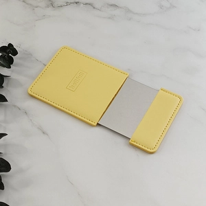 Slim yellow PU leather portable makeup mirror with rectangular glass on marble surface