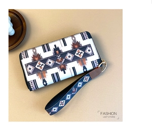 Detailed top view of ethnic pattern women's long wallet with wrist strap on beige background