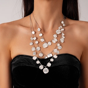 Close-up of three-tier silver necklace with irregular metallic sequins and layered chains