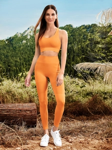 Detail of orange yoga set showing vertical ribbed texture and diamond mesh breathability