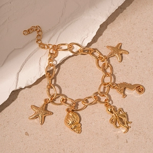 Detailed shot of golden marine charms including seahorse and starfish on a link chain